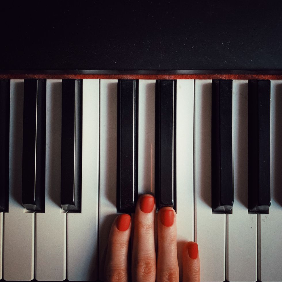 cropped hand of woman playing piano