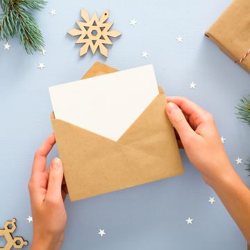 holding a card in an envelope with a blue festive background