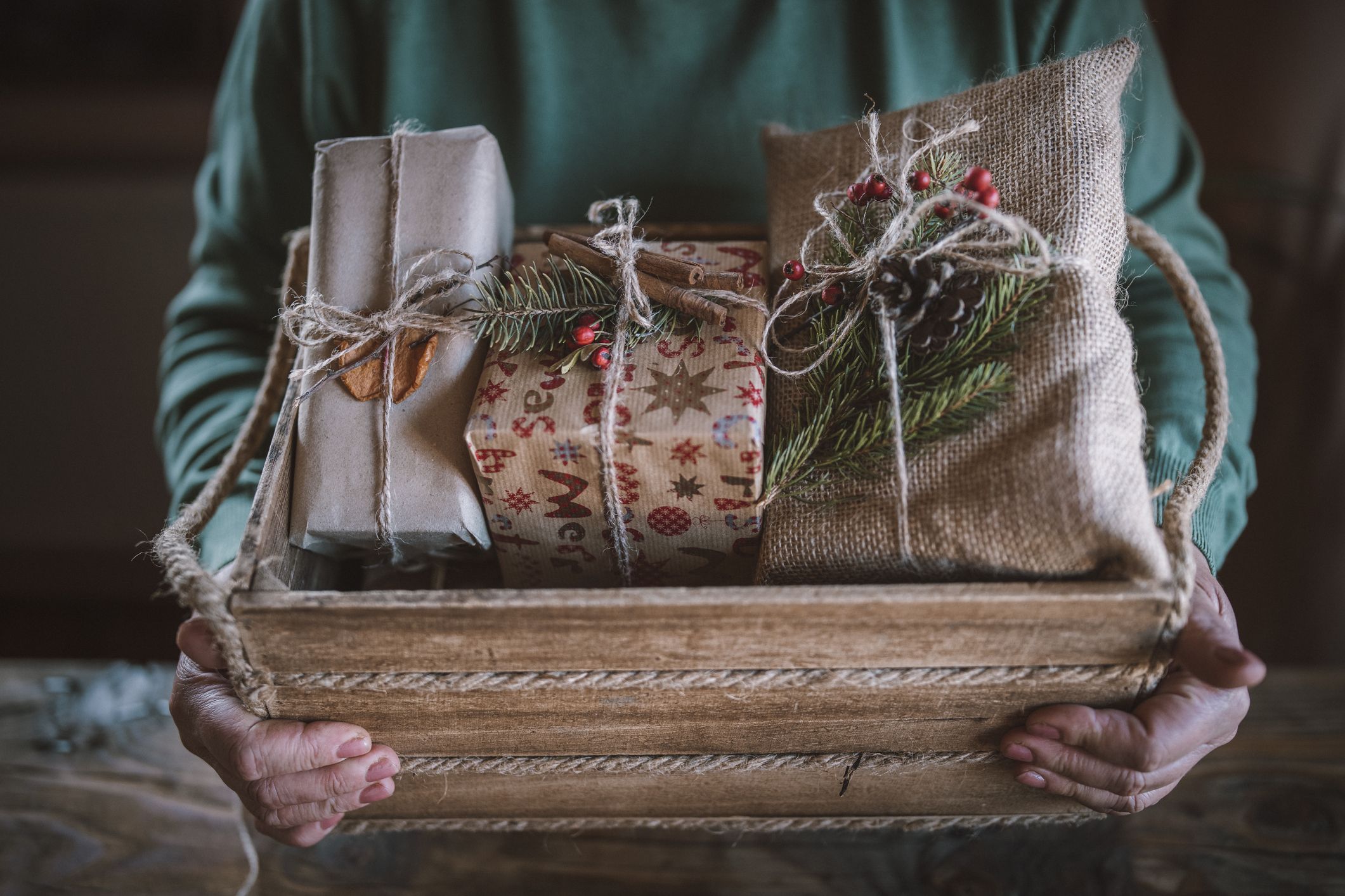 https://hips.hearstapps.com/hmg-prod/images/cropped-hands-arrange-christmas-presents-in-wooden-royalty-free-image-1698247785.jpg