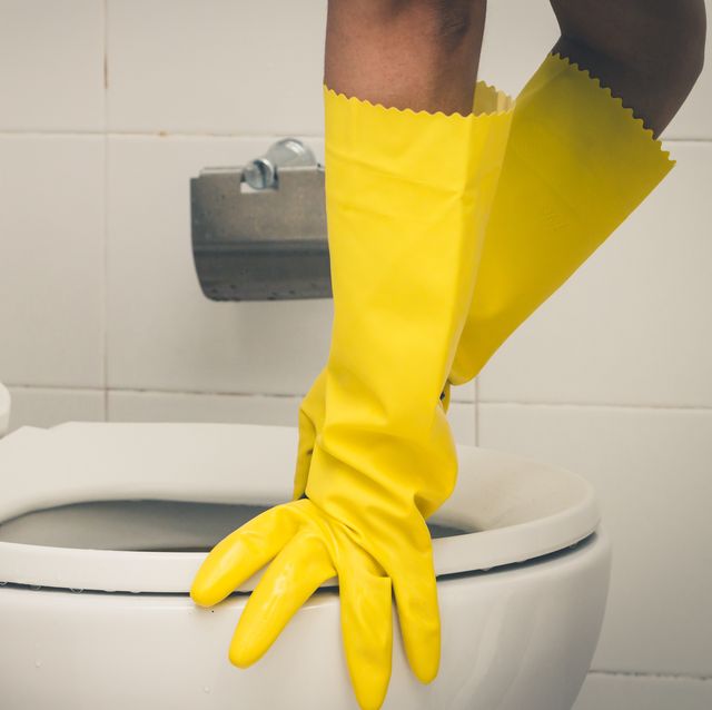 Cropped Hands Cleaning Toilet Bowl In Bathroom