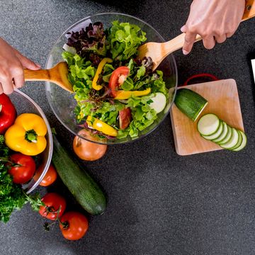 Cropped Hands Making Salad In Bowl