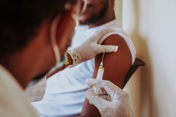 cropped hands of doctor injecting syringe in patient arm,accra,ghana