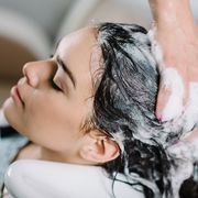 cropped hands of hairdresser washing customer hair at salon