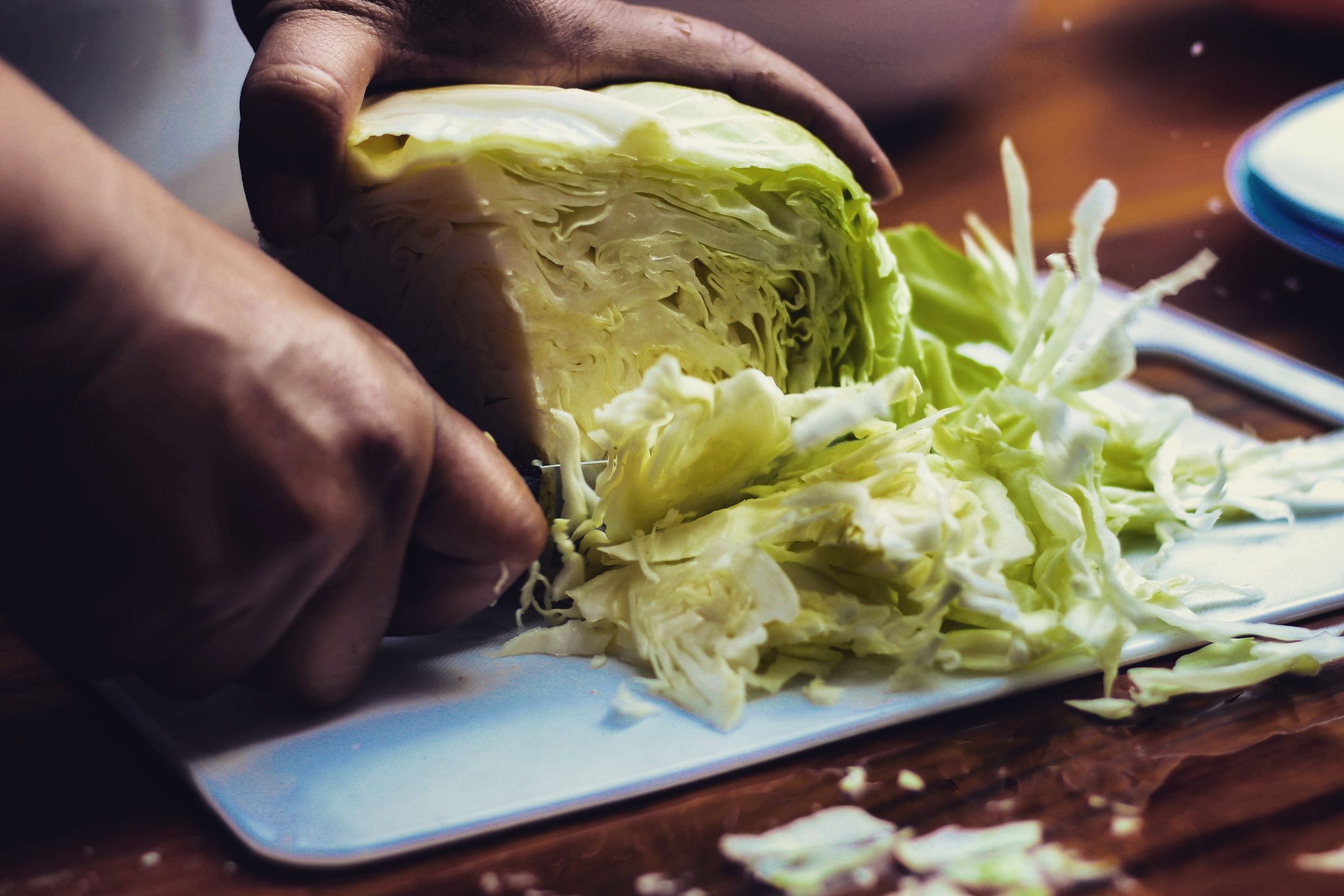 https://hips.hearstapps.com/hmg-prod/images/cropped-hands-of-person-cutting-cabbage-on-table-royalty-free-image-1624276579.jpg?resize=2048:*