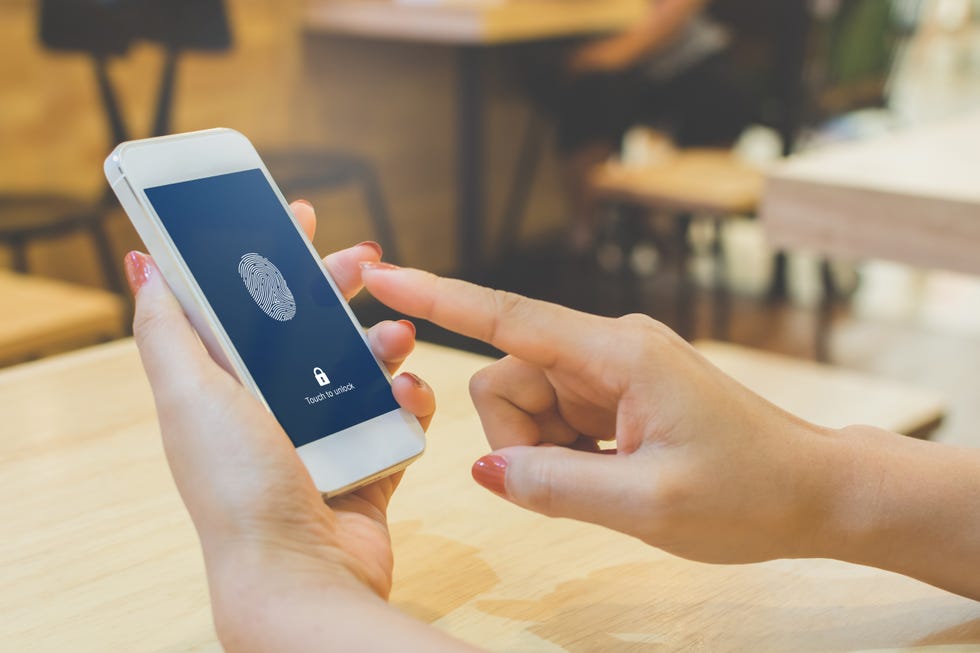 cropped hands of woman using phone on table