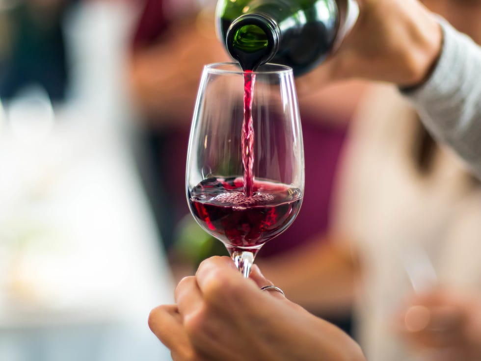 Cropped Hands Pouring Red Wine In Wineglass