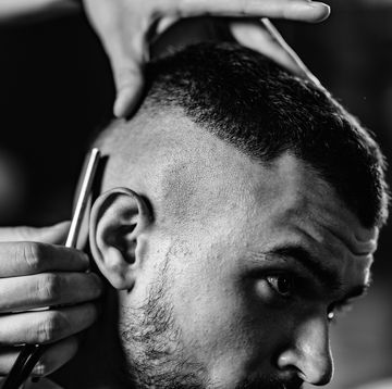 cropped image of barber cutting man hair in shop