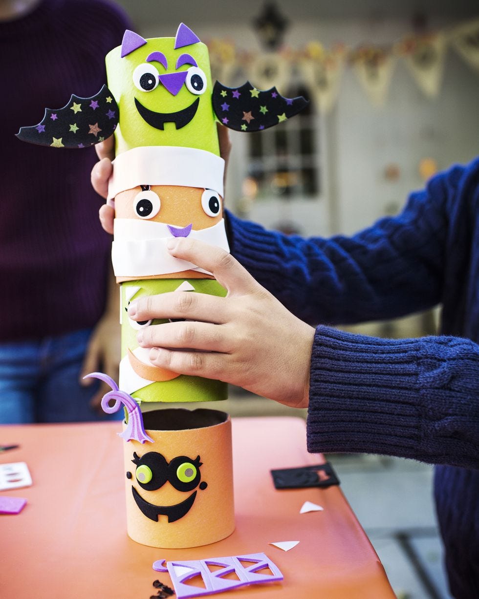 cropped image of boy stacking decoration at table during halloween party