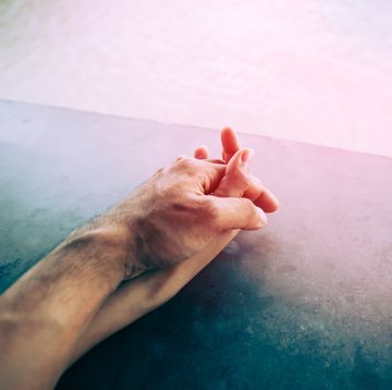 cropped image of couple holding hands by swimming pool
