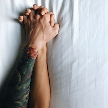 cropped image of couple holding hands on bed at home,thailand