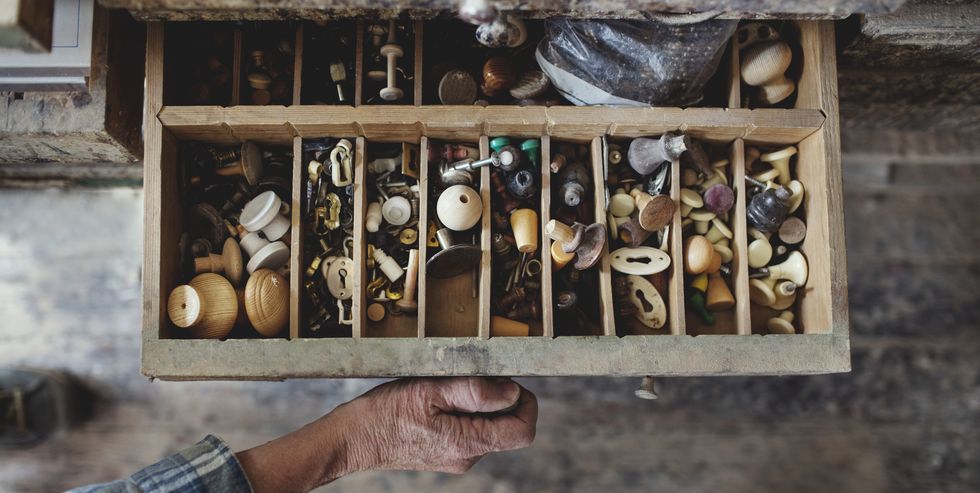 Cropped image of craftsperson opening drawer with knobs at workshop