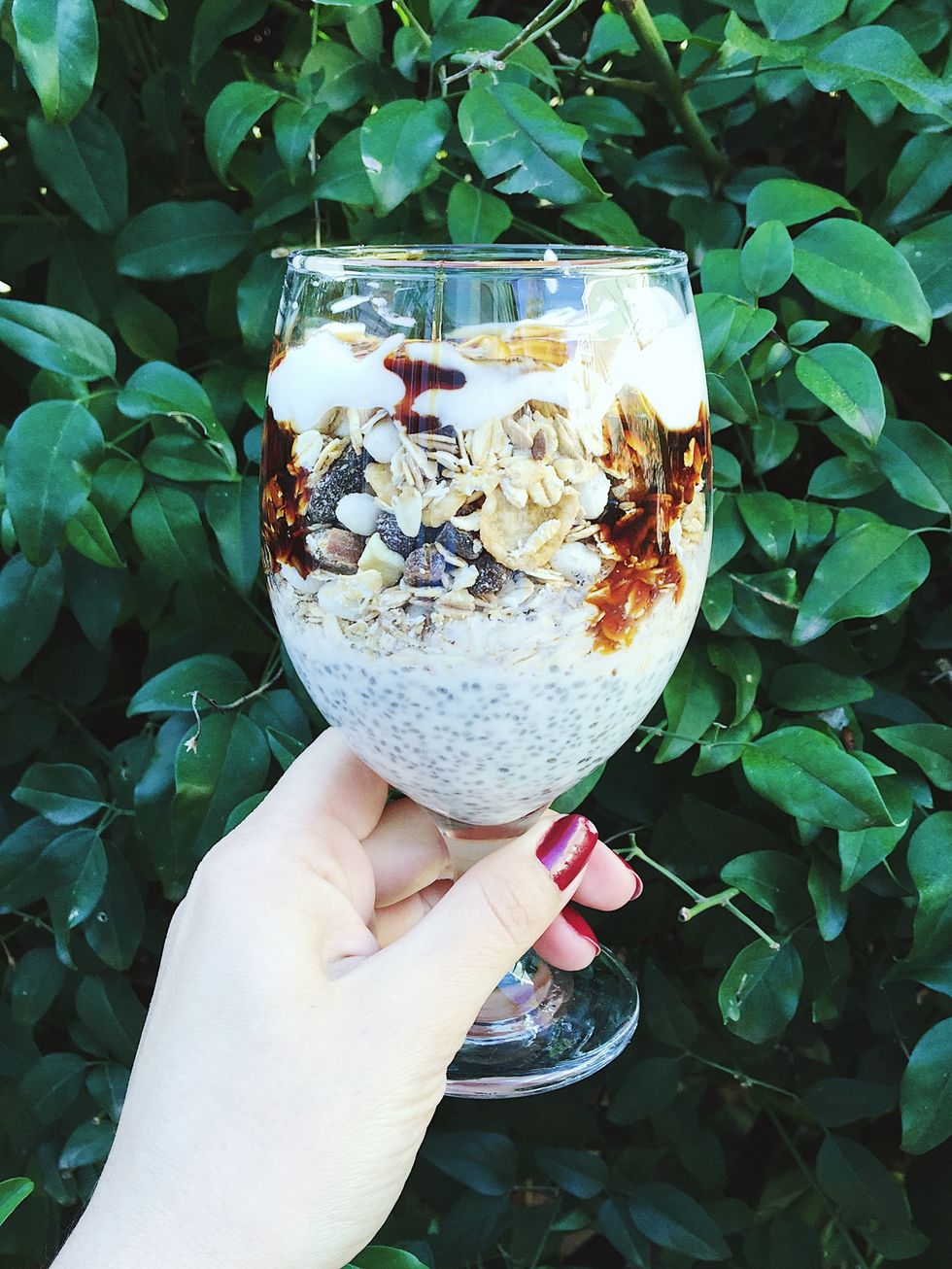 cropped image of hand holding dessert in wineglass