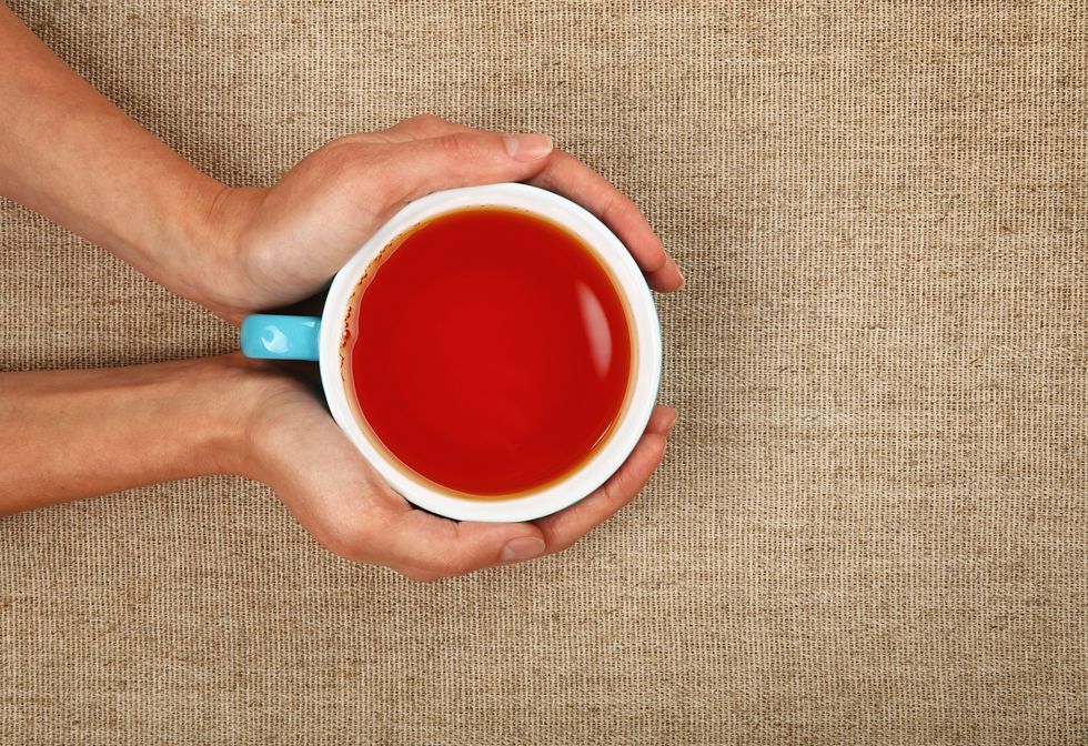 Cropped Image Of Hands Holding Tea Cup