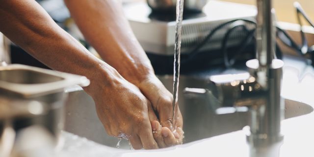 Cropped image of male chef washing hands in sink at commercial kitchen