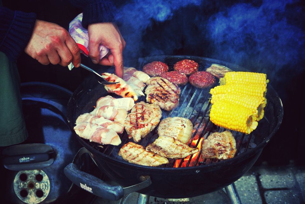 cropped image of man barbequing meat outdoors