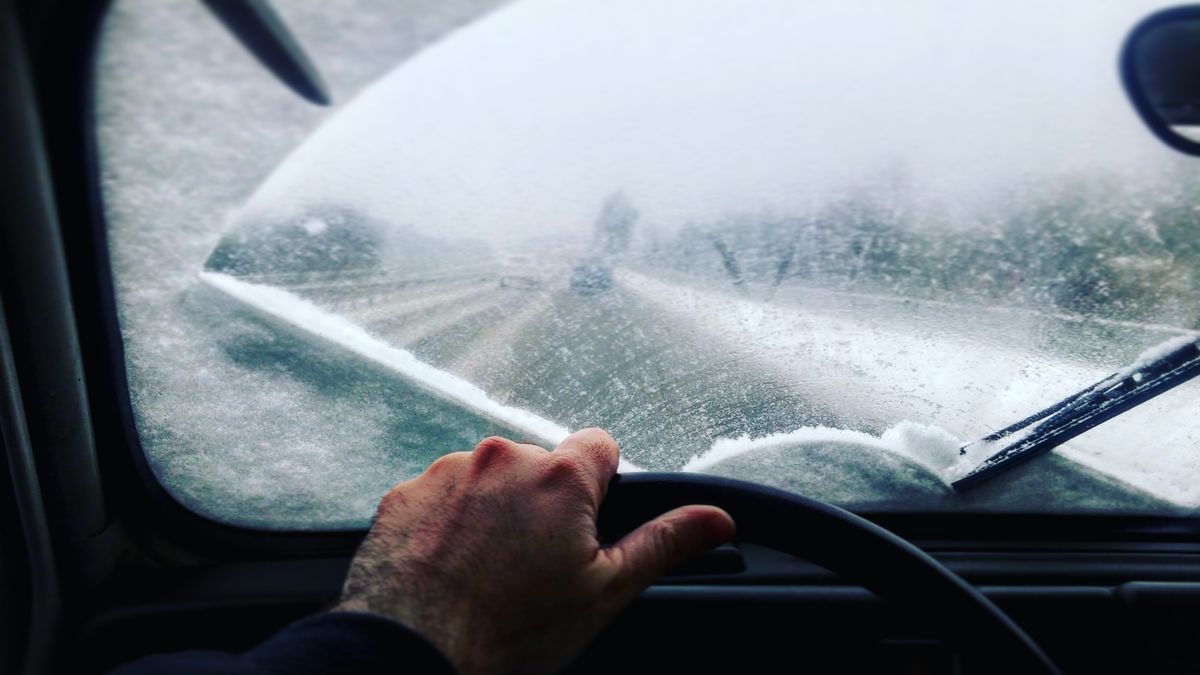 cropped image of man driving car during winter