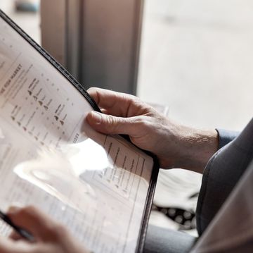 cropped image of man holding menu while sitting in restaurant