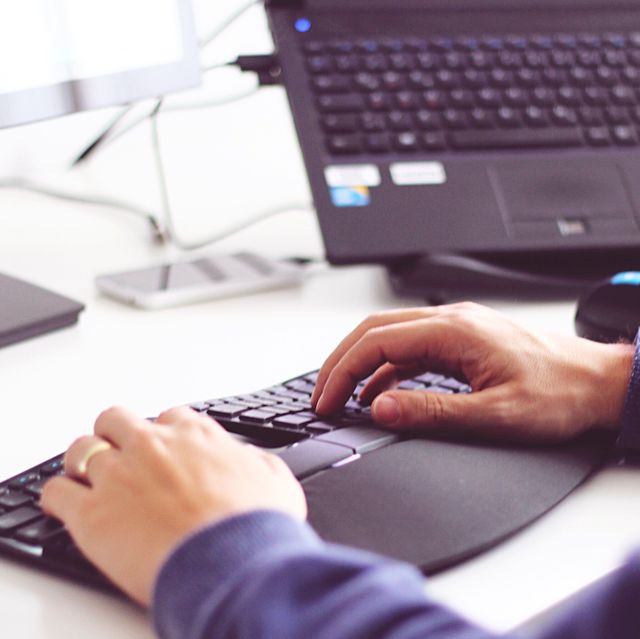 cropped image of man typing on keyboard at desk