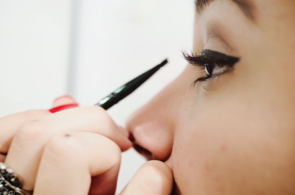 cropped image of woman applying eyeliner