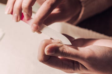 cropped image of woman filing nail at table