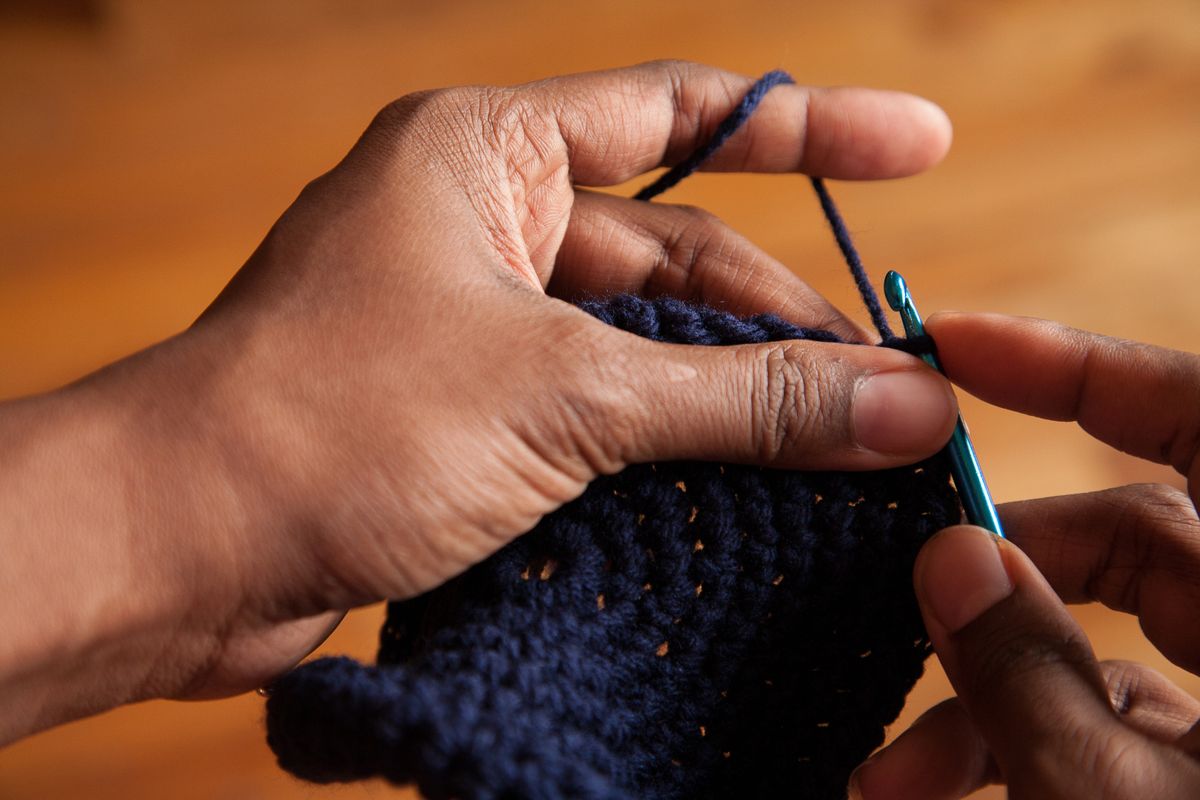 Cropped Image Of Woman Hand Crocheting At Home