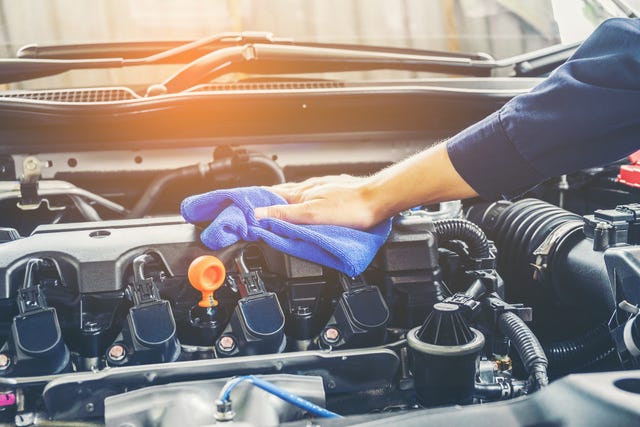 cropped of mechanic cleaning car engine