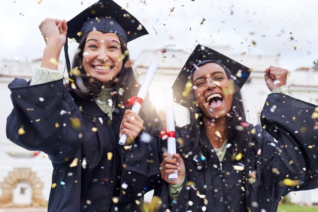 cropped portrait of two attractive young female students celebrating on graduation day