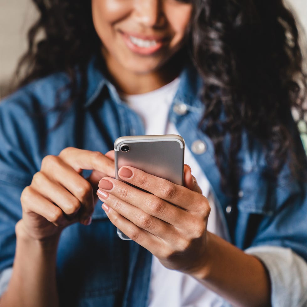 Cropped shot of a young woman using smart phone at home cropped shot of a young woman using smart phone at home
