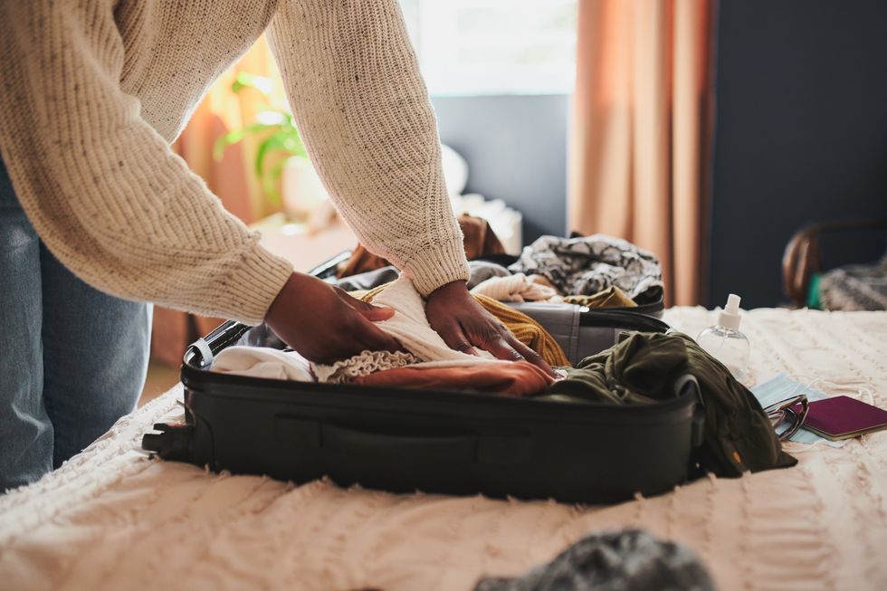woman packing her things into a suitcase at home before travelling