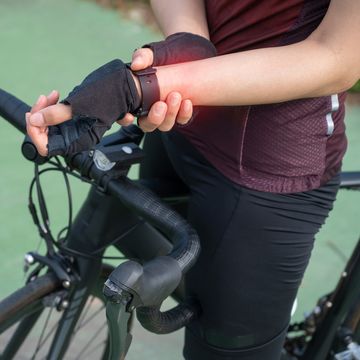 cropped shot of female cyclist holding her wrist caused of wrist pain wrist pain cycling