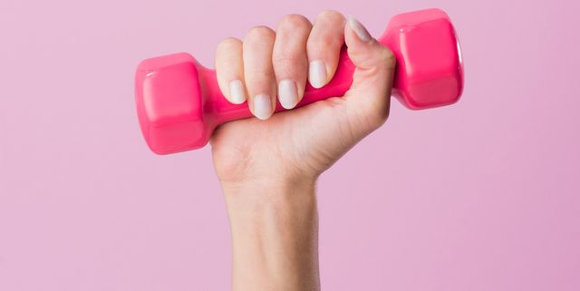 cropped shot of woman holding dumbbell isolated on pink