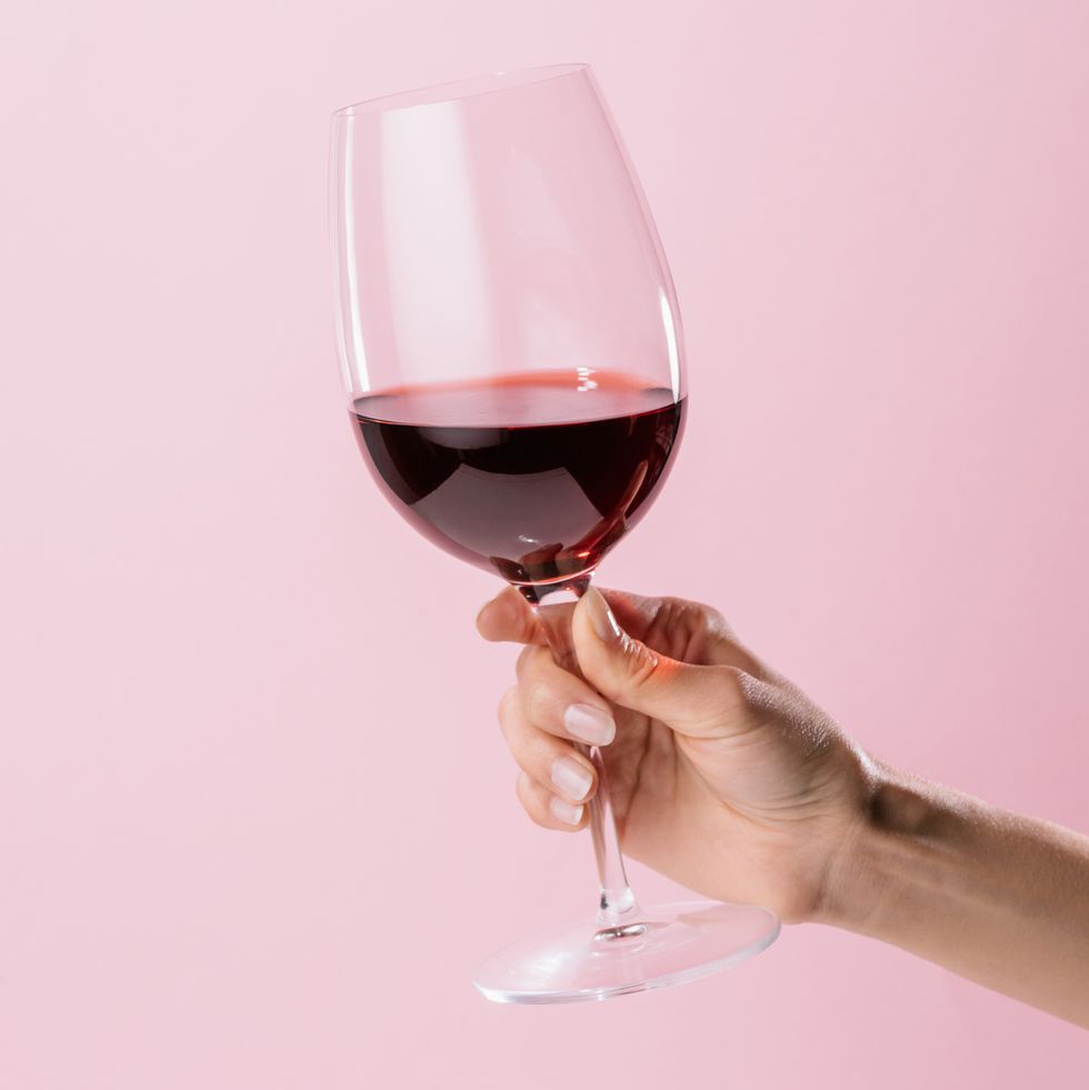 Пара бокалов вина. Держит бокал. Открытка стопка красного вина. Wine Glass in hand.