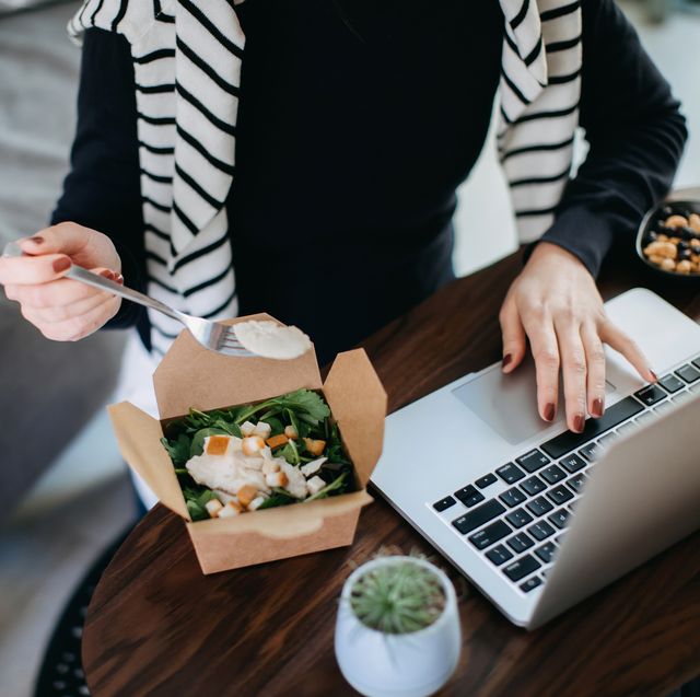 cropped shot of young asian woman eating takeaway meal, a fresh and healthy grilled chicken vegetable salad lunch box while working from home during lunch