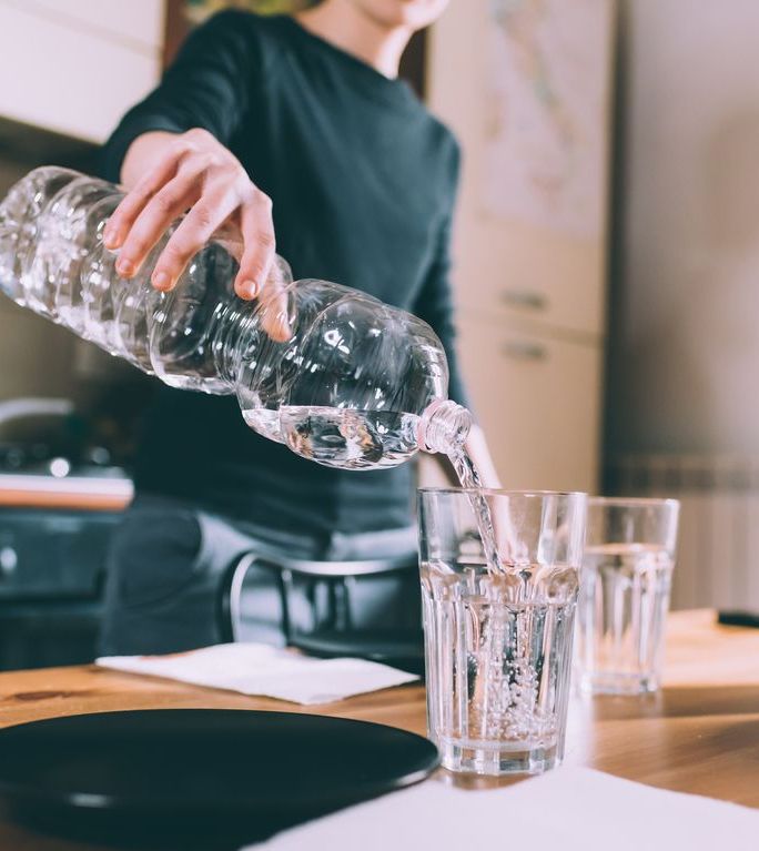 https://hips.hearstapps.com/hmg-prod/images/cropped-shot-of-young-woman-pouring-water-at-royalty-free-image-1582842706.jpg?crop=0.88973xw:1xh;center,top&resize=1200:*