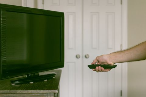 Cropped View of Man with Remote Control in Front of TV