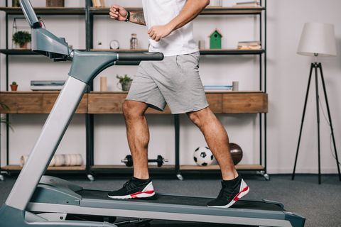 cropped view of muscular sportsman running on treadmill