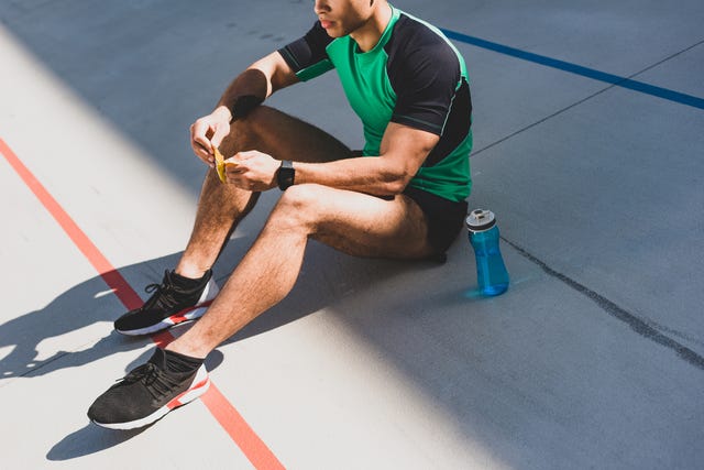 man zit op de grond na sporten