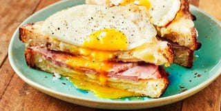 croque madame sandwich with a fried egg on top on a teal plate croque madame sandwich with a fried egg on top on a teal plate