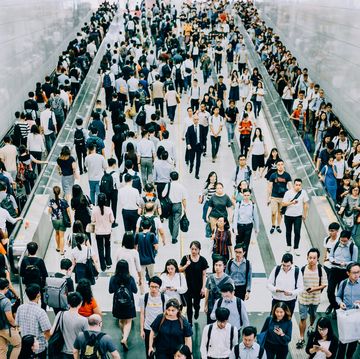 crowd of busy commuters walking through platforms at subway station during office peak hours in the city