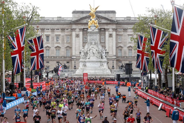 los atletas populares llegan a la meta en the mall por delante del palacio de buckingham durante el maratón de londres 2021