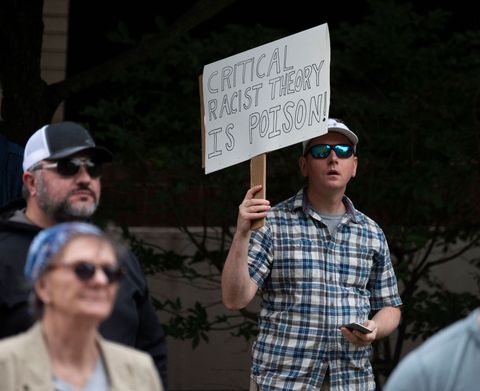 a man holds up a sign during a rally against "critical race theory" crt being taught in schools at the loudoun county government center in leesburg, virginia on june 12, 2021   "are you ready to take back our schools" republican activist patti menders shouted at a rally opposing anti racism teaching that critics like her say trains white children to see themselves as "oppressors" "yes", answered in unison the hundreds of demonstrators gathered this weekend near washington to fight against "critical race theory," the latest battleground of america's ongoing culture wars the term "critical race theory" defines a strand of thought that appeared in american law schools in the late 1970s and which looks at racism as a system, enabled by laws and institutions, rather than at the level of individual prejudices but critics use it as a catch all phrase that attacks teachers' efforts to confront dark episodes in american history, including slavery and segregation, as well as to tackle racist stereotypes photo by andrew caballero reynolds  afp photo by andrew caballero reynoldsafp via getty images