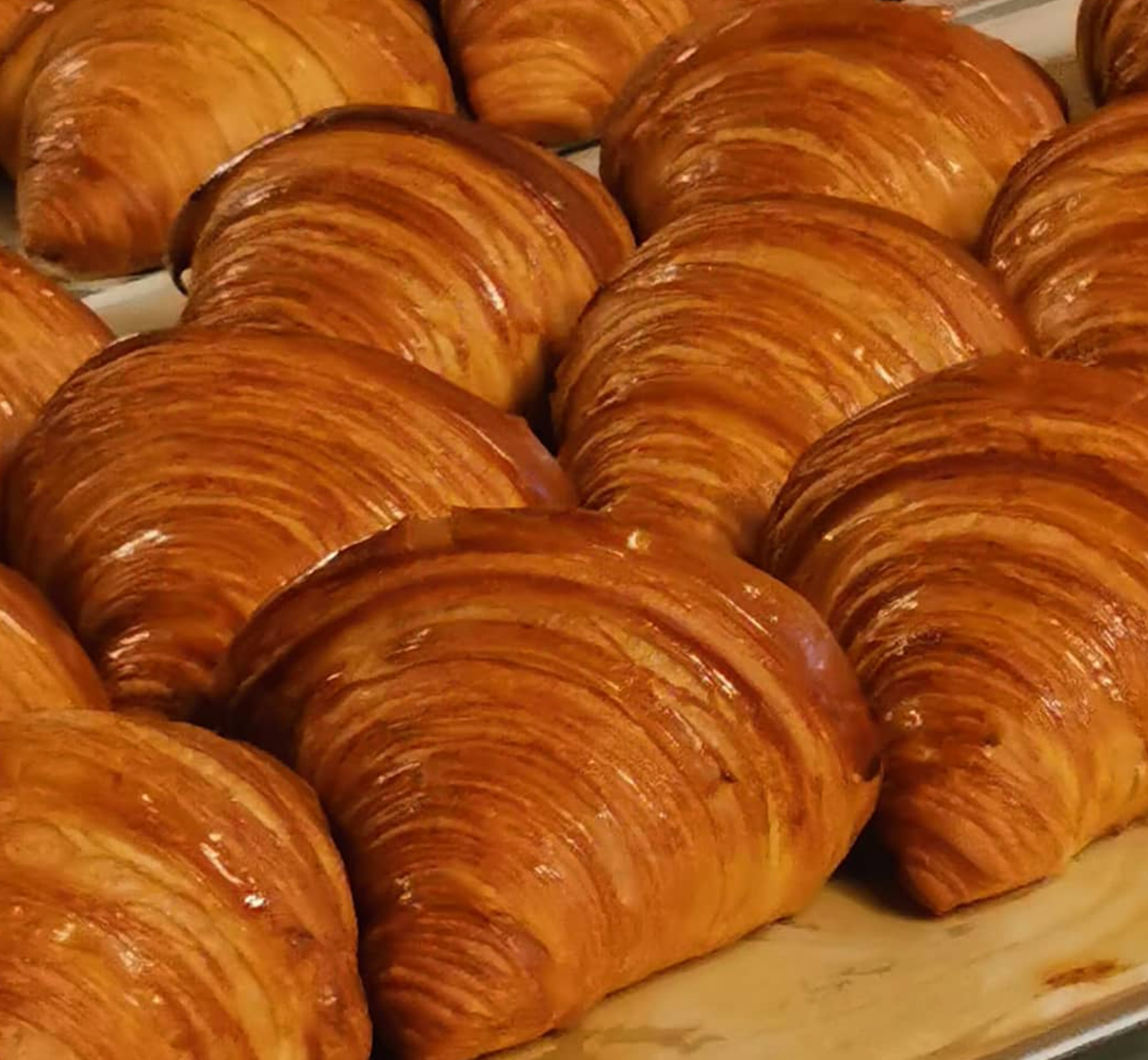 Las turistas francesas alaban el croissant de mantequilla cántabra que preparan en esta pastelería del centro de Madrid de martes a domingo