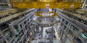 a huge, circular steel base being lifted and transported through iter's tokamak facility