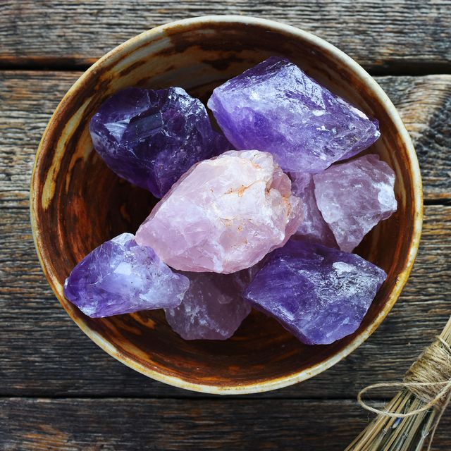 a table top image of a pottery bowl with large rose quartz and amethyst crystal with dried lavender flowers