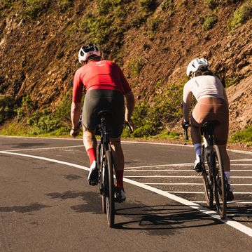 two people riding bikes on a road