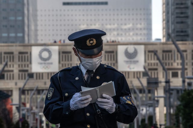 Un policía consulta su libreta mientras se corre el maratón de Tokio.