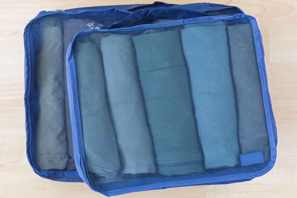 cube meshed bags with rolled clothes. set of travel organizer to help packing well organized