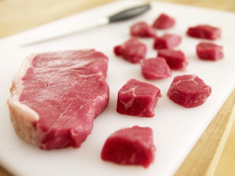 cubed raw steak on cutting board