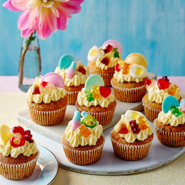 cupcakes with frosting and pick 'n' mix toppings on a plate