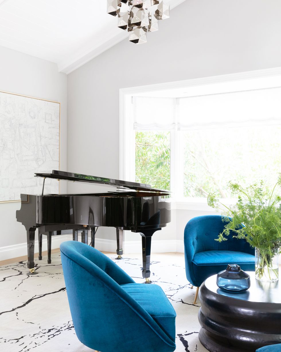living room with grand piano and blue chairs